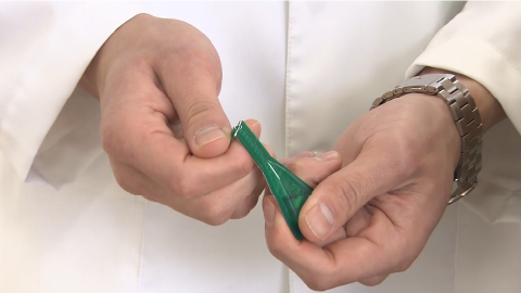 写真:STEP3 緑の面を手前に向けて折ると、薬液が体に飛び散ることがありますので、図のように裏の白い面を体の方に向けて折ってください。